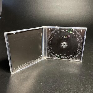 May include: A clear plastic CD case with a black CD inside. The CD has the text "Adele 19" and "Columbia" printed on it.
