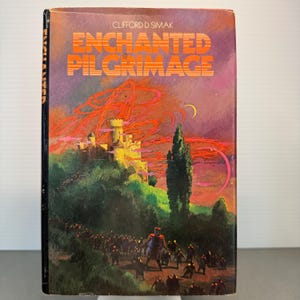May include: A vintage paperback book titled "Enchanted Pilgrimage" by Clifford D. Simak. The cover features a castle on a hill, a procession of figures, and a vibrant sky with orange and purple hues. The book's title is in orange.