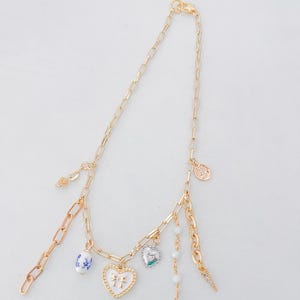 Vintage-Inspired Gold Charm Necklace – Heart, Bow, Porcelain Bead & Crystal Drop – Asymmetrical Statement Jewelry – Unique Gift for Her