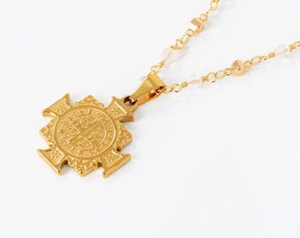 May include: Gold chain necklace with a gold St. Christopher medal pendant. The medal has a detailed design and is attached to the chain with a gold loop.