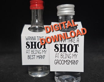 May include: Two small glass bottles with white labels. The labels have black text that reads "Wanna take a shot at being my best man?" and "Wanna take a shot at being my groomsman?"