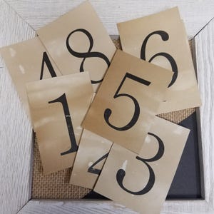 May include: A set of nine brown paper cards with black numbers printed on them. The numbers are 1, 2, 3, 4, 5, 6, 7, 8, and 9.