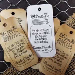 May include: Brown and white paper tags with the text "Hot Cocoa Mix" and instructions for making hot cocoa. The tags also include the names "Alexander & Samantha" and the date "December 2019".
