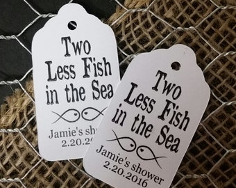 May include: Two white gift tags with black text that reads "Two Less Fish in the Sea" and a drawing of two fish. The tags also include the date "2.20.2016" and the name "Jamie's shower".