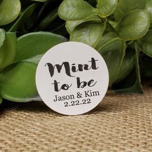 May include: White round sticker with black text that reads "Mint to be Jason & Kim 2.22.22".
