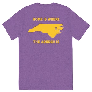 Peut inclure: T-shirt violet avec un contour jaune de l'état de Caroline du Nord et le texte "HOME IS WHERE THE ARRRGH IS".