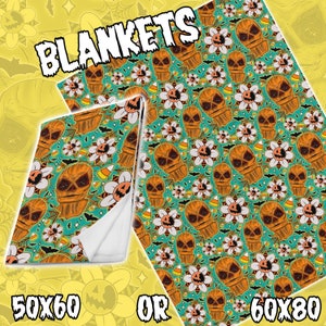May include: Halloween themed blanket with a repeating pattern of orange and brown cartoon faces with white flowers and candy corn on a teal background. The blanket is available in two sizes: 50x60 inches or 60x80 inches.