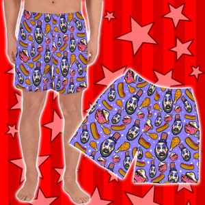 May include: Purple men's boxer shorts with a repeating pattern of a man's face wearing a red, white, and blue hat, hot dogs, and fried chicken legs.