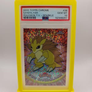 May include: A graded Pokemon trading card featuring Sandslash from the 2000 Topps Chrome Pokemon T.V. - Sparkle series. The card is graded GEM MT 10 and has a PSA number of 52348291.
