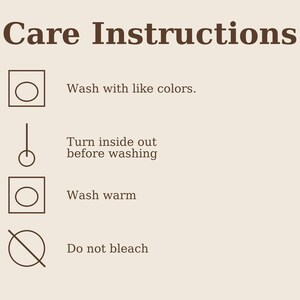 May include: A tan background with brown text and care symbols. The text reads "Care Instructions" and provides washing guidelines: wash with similar colours, turn inside out before washing, wash warm, and do not bleach.