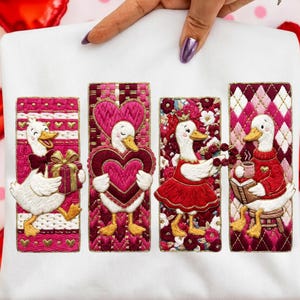May include: White sweatshirt featuring four embroidered panels with Valentine's Day themed geese. Each goose is depicted in a different pose, holding gifts, hearts, flowers, and a book. The panels are framed in shades of pink and red.