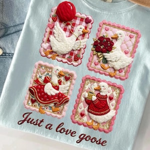 May include: Light blue t-shirt featuring four embroidered patches with white geese. Each goose is depicted with different accessories, including a balloon, flowers, and a sweater. The text "Just a love goose" is embroidered in a cursive font.