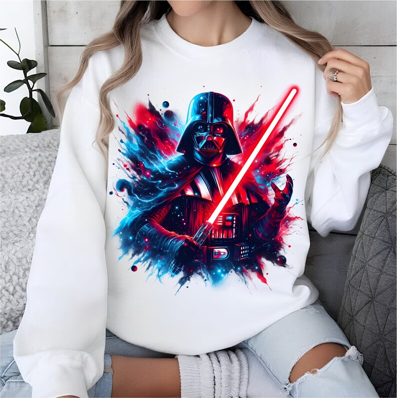 May include: White sweatshirt with a colorful graphic print of Darth Vader holding a red lightsaber. The background is a blue and red abstract design.