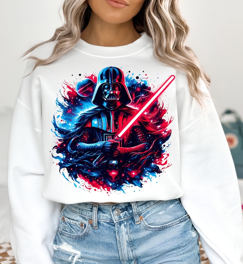 May include: White sweatshirt with a graphic print of Darth Vader holding a lightsaber in front of a galaxy background with red and blue colors.