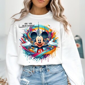 May include: White sweatshirt with a colorful graphic of Mickey Mouse in front of a castle. The graphic includes splashes of paint in shades of blue, yellow, orange, pink, and purple.