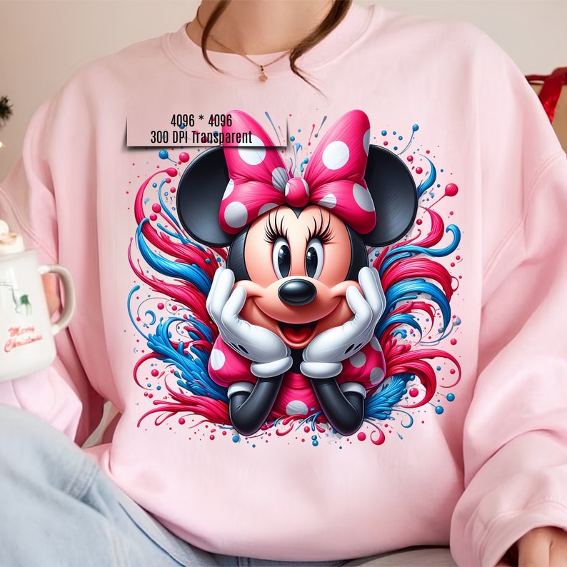 Puede incluir: Sudadera rosa claro con un gr&aacute;fico colorido de Minnie Mouse. Minnie Mouse lleva un lazo y un vestido de lunares rosas, y guantes blancos. El dise&ntilde;o incluye elementos decorativos rojos y azules.