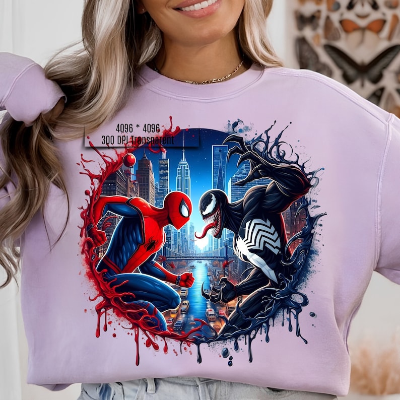 May include: A purple sweatshirt with a graphic print of Spider-Man and Venom fighting in a city setting. The graphic is surrounded by red and black splatters.