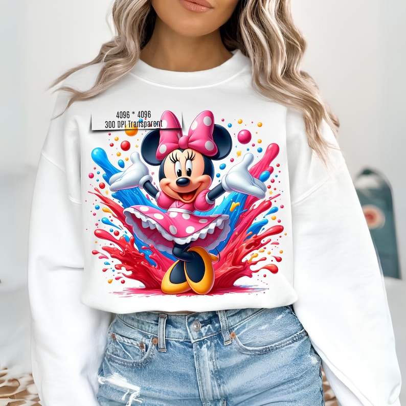 May include: White sweatshirt with a colorful graphic print of Minnie Mouse in a pink polka dot dress. The graphic features Minnie Mouse with a pink bow and surrounded by colorful paint splatters.