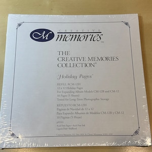 May include: A white package with a blue and white logo for Creative Memories. The package contains refill pages for expanding photo albums. The text on the package reads "Holiday Pages" and "REFILL RCM-12H".