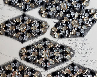 May include: Eight black mesh appliques with gold and clear rhinestones. The appliques are in the shape of a diamond and have a floral design.