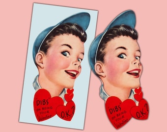 May include: Vintage Valentine's Day card featuring a smiling boy in a blue cap. The card has red hearts with the text "Dibs on being your Valentine O.K.?" on a light blue background, with a pink background.