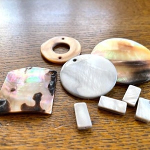 May include: Assortment of iridescent shell and mother of pearl jewelry making supplies.  The set includes a round, a square, and an oval shaped shell, as well as four small rectangular pieces.