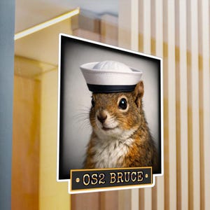 May include: A white ceramic mug with a black handle and the text "But First, Coffee" in a black, handwritten-style font. The mug is on a white surface.