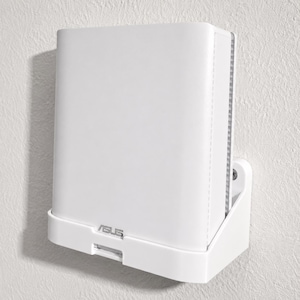 May include: A white wall-mounted plastic bracket holding a white ASUS router. The bracket features a rectangular base with a front lip and a vertical support piece secured to the wall with a visible screw, providing a stable mount for the device.