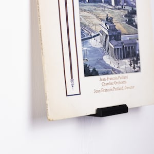 Może przedstawiać: Czarny stojak na płyty winylowe z płytą przedstawiającą lotniczy widok Bramy Brandenburskiej w Berlinie, Niemcy. Tekst na okładce płyty brzmi "Jean-François Paillard Chamber Orchestra Jean-François Paillard, Director".