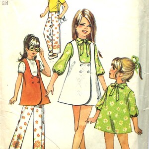 May include: A vintage sewing pattern for girls' clothing. The pattern includes three different styles: a white dress with a vest, a green dress with a bow, and a white and orange pantsuit. The pattern is for size 12, with a 30-inch bust. The pattern number is 8716.