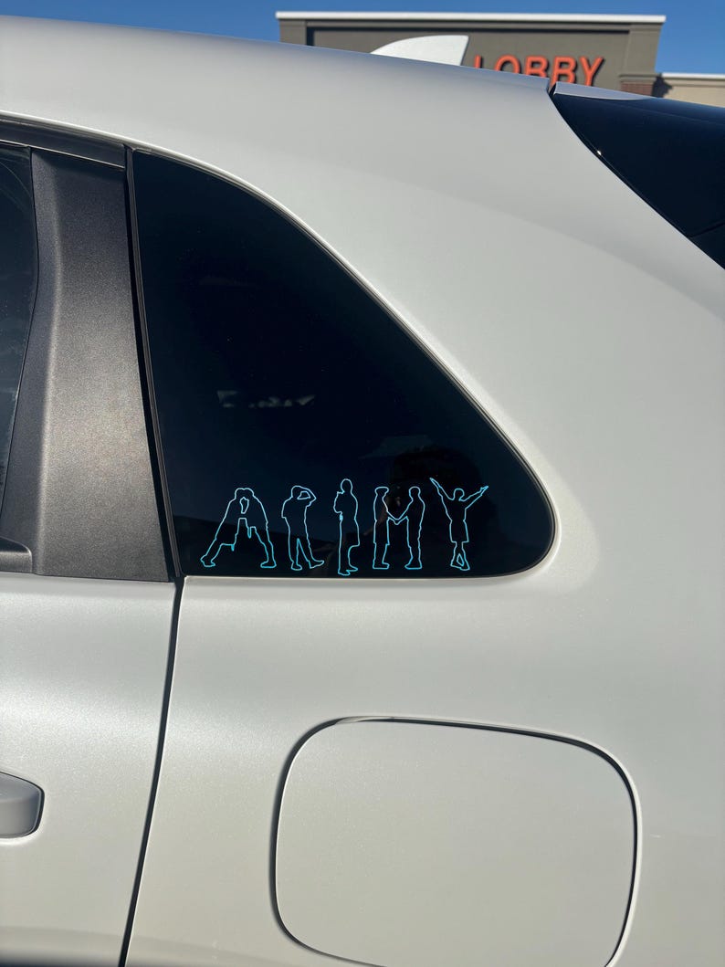 Puede incluir: Una calcoman&iacute;a de vinilo azul claro aplicada en la ventana de un coche, que muestra la palabra ARMY formada por las siluetas de siete figuras en varias poses, con cada letra delineada por una fina l&iacute;nea de color azul cian brillante.