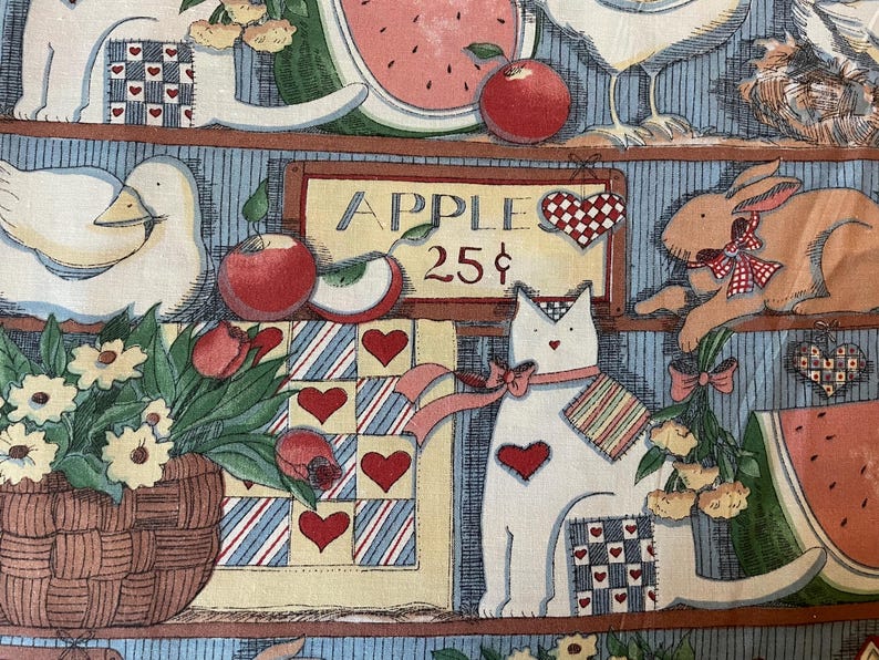 K&ouml;nnte beinhalten: Ein farbenfroher Stoff mit einem Bauernhof-Thema. Der Stoff zeigt eine wei&szlig;e Katze, ein wei&szlig;es Huhn, ein braunes Kaninchen, einen Blumenkorb, eine Wassermelone und &Auml;pfel. Der Stoff hat auch ein Schild mit der Aufschrift "Apple 25&cent;".