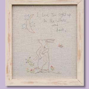 May include: Embroidered artwork in a distressed white frame. The image features a rabbit and a smaller rabbit, with a butterfly and floral accents. Text reads "I Love You right up to the stars... and back."