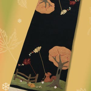 May include: Black table runner with an autumn theme. Features appliqued trees, leaves, and a squirrel. Includes a small fence and text that reads "Come Fille leaves..." in a whimsical font. The runner is approximately 12 inches wide.