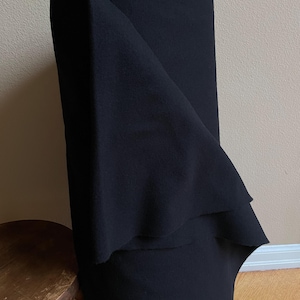 May include: A roll of black fabric folded in half. The fabric is soft and has a smooth texture.