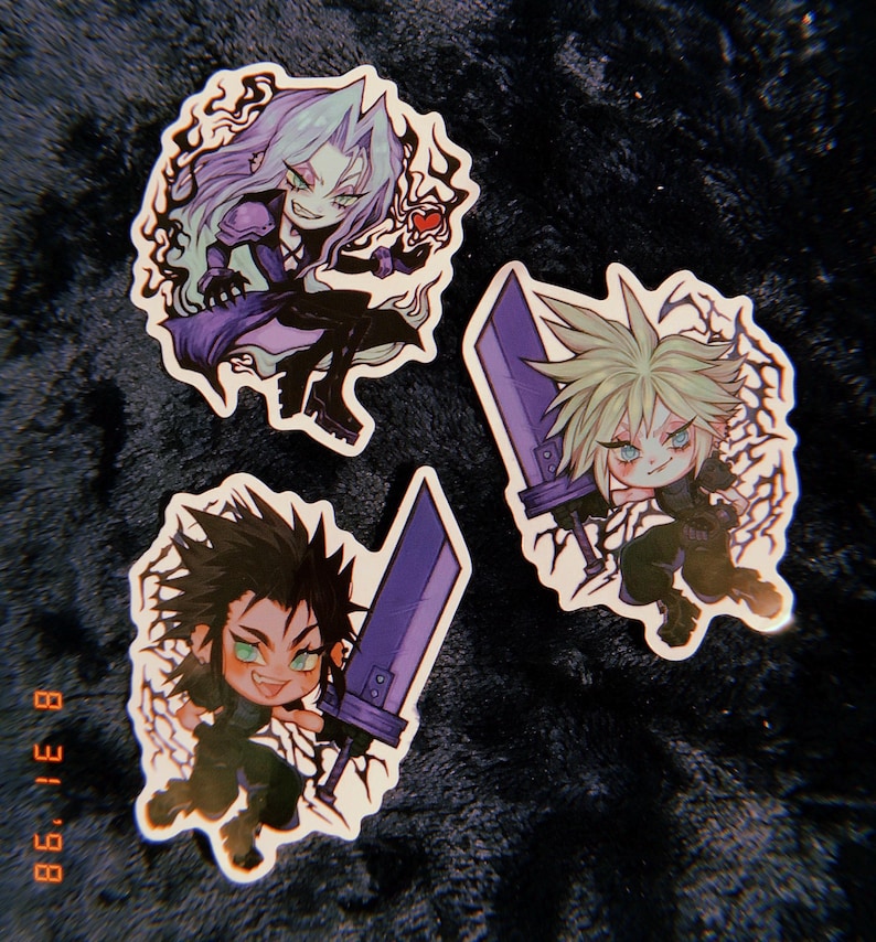 May include: Three cartoon stickers featuring characters from the Final Fantasy VII video game. The stickers are on a dark gray fuzzy surface. The characters are Cloud, Sephiroth, and Tifa. Each character is holding a sword and has a menacing expression.