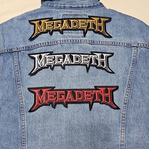 May include: A denim jacket with three Megadeth patches sewn on the back. The patches are in gold, white, and red.