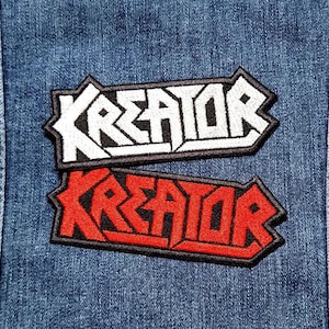 May include: Two embroidered patches with the word "Kreator" in white and red lettering on a denim background.
