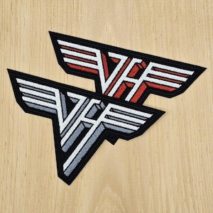 May include: Two embroidered patches featuring the iconic "VH" logo in a stylized wing design. One patch has a red and white color scheme, while the other is gray and white. Both are outlined in black and rest on a light wood grain surface.