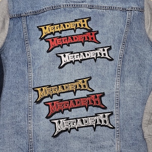 May include: A denim jacket with six Megadeth patches sewn on the back. The patches are in different colors, including yellow, red, and white.