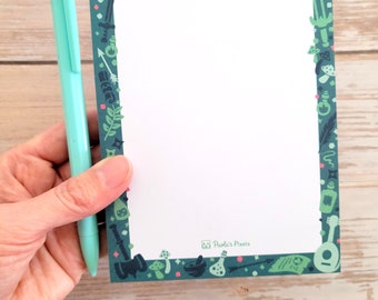 Puede incluir: Un bloc de notas verde y blanco con un borde de ilustraciones de temática fantástica. El borde incluye espadas, pociones, dados y otros objetos mágicos. El bloc de notas tiene el texto "Pawlick's Pixels" en la parte inferior.