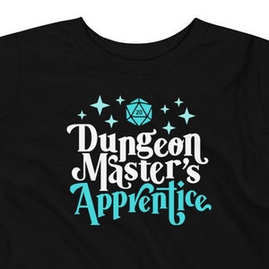 May include: Black toddler t-shirt with a blue and white graphic of a 20-sided die and the text "Dungeon Master's Apprentice".