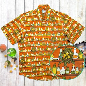 May include: Orange button-down shirt with a repeating pattern of colorful potion bottles, books, and greenery. The short-sleeved shirt has a classic collar and a detailed, whimsical design. The pattern includes various shapes and sizes of bottles in shades of yellow, green, and white.