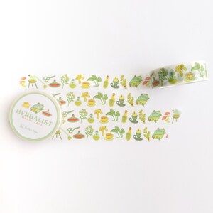 K&ouml;nnte beinhalten: Eine Rolle Washi-Tape mit einem gr&uuml;n-gelb-orangenen Muster mit Illustrationen von Kr&auml;utern, Flaschen und anderen botanischen Elementen. Das Band ist mit "Herbalist Washi Tape" und "Studio Press" beschriftet.