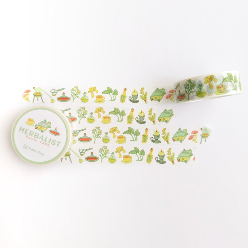 K&ouml;nnte beinhalten: Eine Rolle Washi-Tape mit einem gr&uuml;n-gelb-orangenen Muster mit Illustrationen von Kr&auml;utern, Flaschen und anderen botanischen Elementen. Das Band ist mit "Herbalist Washi Tape" und "Studio Press" beschriftet.