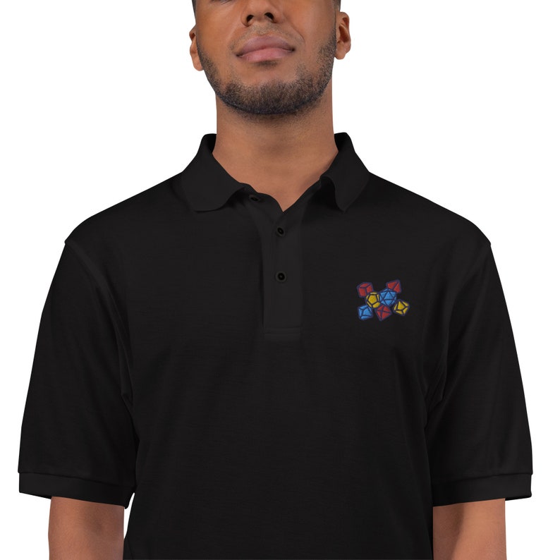 May include: A black polo shirt with an embroidered design of colorful dice.