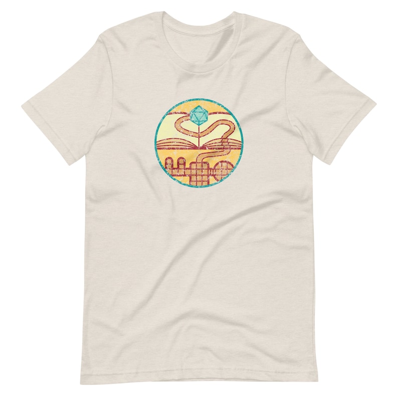 May include: A beige t-shirt with a vintage-style circular graphic. The graphic features a stylized book with a winding path leading to a blue and green dice.