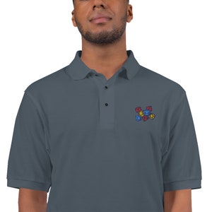 May include: A dark blue polo shirt with an embroidered design of colorful dice.