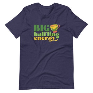 May include: A navy blue t-shirt with the text "BIG halfling energy" in green and yellow lettering. A small yellow teacup with green leaves is above the text.
