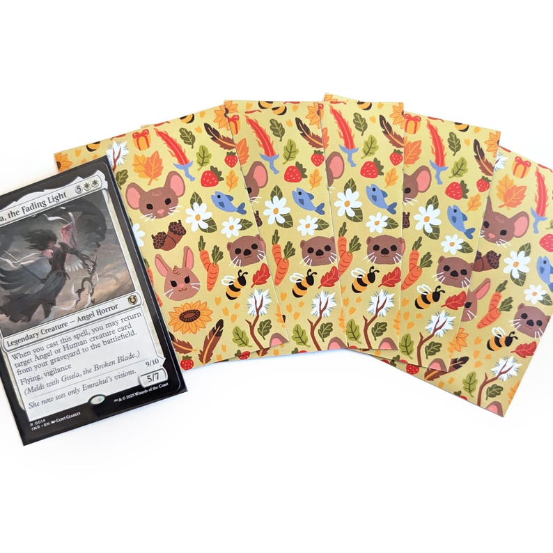 May include: A Magic: The Gathering card and several card sleeves. The card features a black and white illustration of a winged figure. The sleeves have a yellow background with a repeating pattern of cartoon animals, flowers, and other natural elements.